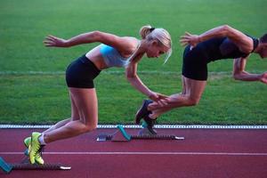 vrouw groep rennen Aan atletiek ras bijhouden van begin foto