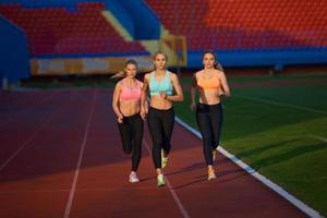 atleet vrouw groep rennen Aan atletiek ras bijhouden foto
