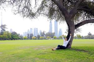 mooi jong vrouw met tablet in park foto