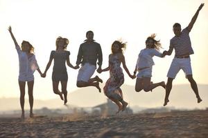 gelukkig jong mensen groep hebben pret Aan strand foto