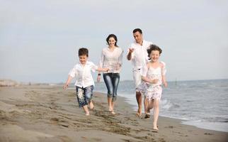 gelukkig jong familie hebben pret Aan strand foto