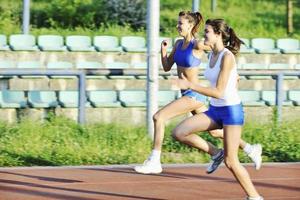 twee meisjes rennen Aan atletisch ras bijhouden foto