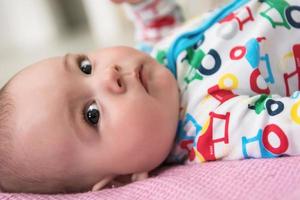 pasgeboren baby jongen aan het liegen Aan kleurrijk dekens foto