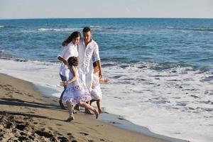 gelukkig jong familie hebben pret Aan strand foto