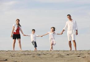 gelukkig jong familie hebben pret Aan strand foto