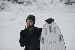 arctisch surfer portret Holding een bord na surfing in Noors zee foto