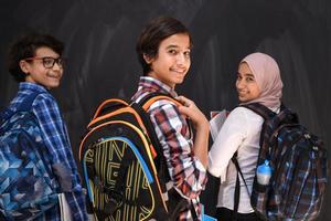 Arabisch tieners, studenten groep portret tegen zwart schoolbord vervelend rugzak en boeken in school.selectief focus foto