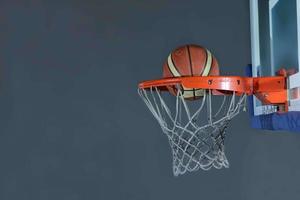 basketbal bal en netto Aan grijs achtergrond foto
