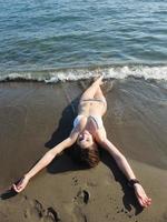 jong vrouw kom tot rust Aan strand foto