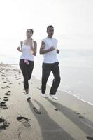 paar jogging Aan de strand foto