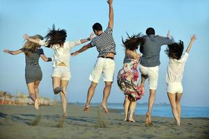 gelukkig jong mensen groep hebben pret Aan strand foto