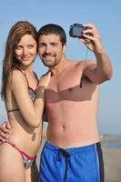 gelukkig jong paar in liefde nemen foto's Aan strand foto