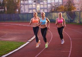 atleet vrouw groep rennen Aan atletiek ras bijhouden foto