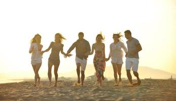 gelukkig jong mensen groep hebben pret Aan strand foto