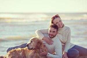 paar met hond genieten van tijd Aan strand foto