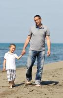 gelukkig vader en zoon hebben pret en genieten tijd Aan strand foto