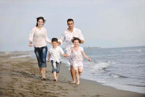 gelukkig jong familie hebben pret Aan strand foto