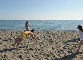 jong mensen groep hebben pret en Speel strand volleybal foto