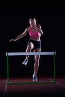 vrouw atleet jumping over- een hindernissen foto