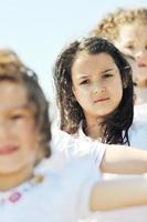 gelukkig kind groep spelen op strand foto