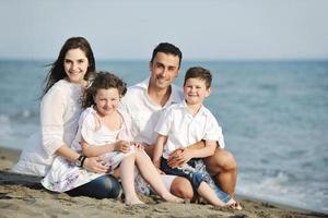 gelukkig jong familie hebben pret Aan strand foto