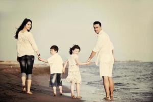 gelukkig jong familie hebben pret Aan strand foto