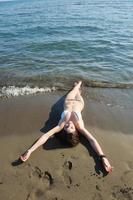jong vrouw kom tot rust Aan strand foto