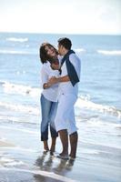 gelukkig jong paar hebben pret Bij mooi strand foto