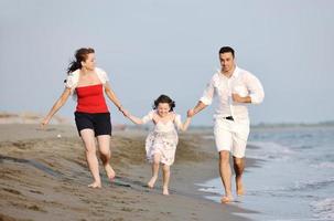 gelukkig jong familie hebben pret Aan strand foto