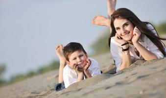 mam en zoon ontspannende Aan strand foto