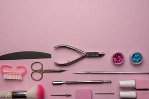 reeks van manicure gereedschap en accessoires Aan een roze achtergrond. hardware manicure, plat leggen. foto