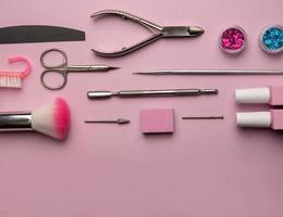 reeks van manicure gereedschap en accessoires Aan een roze achtergrond. hardware manicure, plat leggen. foto