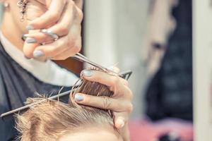 dichtbij omhoog van haar stylist snijdend jongens haar. foto