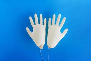 paar- van beschikbaar medisch handschoenen Aan blauw achtergrond met kopiëren ruimte. concept van nieuw normaal levensstijl. foto