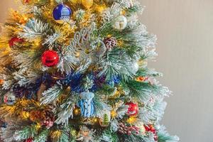 klassiek Kerstmis versierd nieuw jaar boom met rood blauw en wit ornament speelgoed- en bal Aan grijs muur achtergrond. modern klassiek stijl interieur ontwerp appartement. Kerstmis vooravond Bij huis. kopiëren ruimte. foto