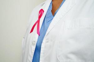 Aziatisch vrouw dokter met roze lint, wereld borst kanker dag Bij oktober. foto