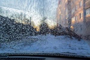 ochtend- auto voorruit met vorst en sneeuwvlokken, visie van binnen foto