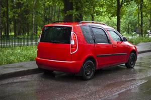 rood auto in de parkeren kavel. de auto is Aan de weg. foto