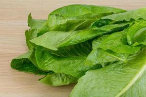 romano salade Aan houten achtergrond foto