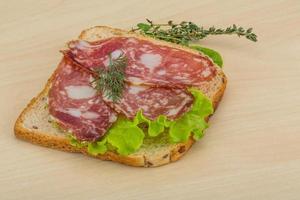 salami belegd broodje Aan houten achtergrond foto