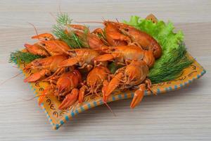 gekookt rivierkreeft Aan de bord en houten achtergrond foto