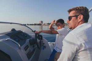 vader en zoon genieten hun vakantie samen terwijl rijden een luxe boot Bij zee. selectief focus foto