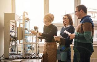 jong studenten aan het doen praktijk in de elektronisch klas foto