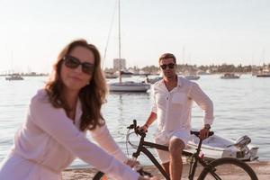 senior paar genieten van een mooi ochtend- samen rijden een fiets door de zee. selectief focus foto