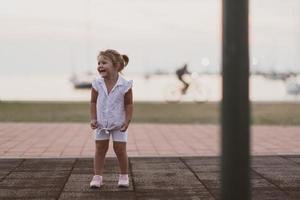een weinig meisje in modern zomer kleren spelen in de park in zomer. selectief focus foto