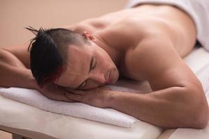 knap Mens resting in een spa massage centrum foto