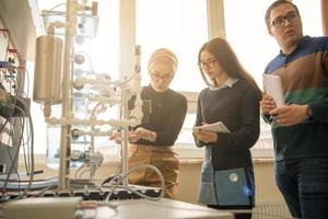 jong studenten aan het doen praktijk in de elektronisch klas foto