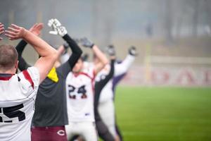 Amerikaans Amerikaans voetbal spelers uitrekken en opwarming omhoog foto