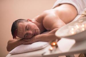 knap Mens resting in een spa massage centrum foto