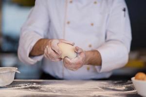 chef handen voorbereidingen treffen deeg voor pizza foto